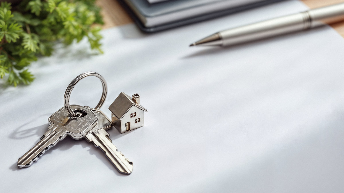 une petite maison accompagnée d'un jeu de clé sont posés sur un document